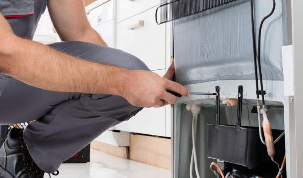 técnico consertando geladeira em casa