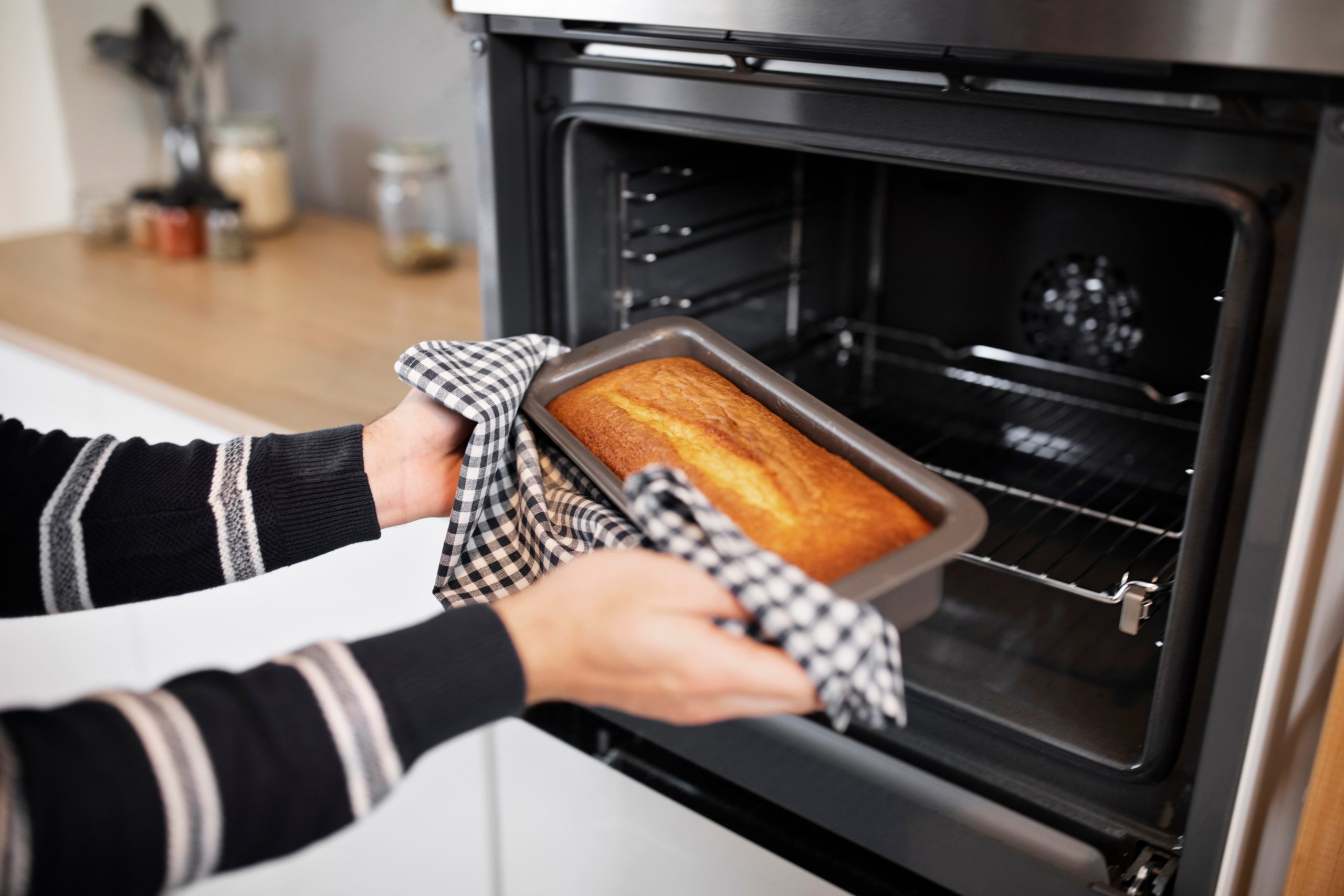 pessoa tirando um bolo do forno elétrico