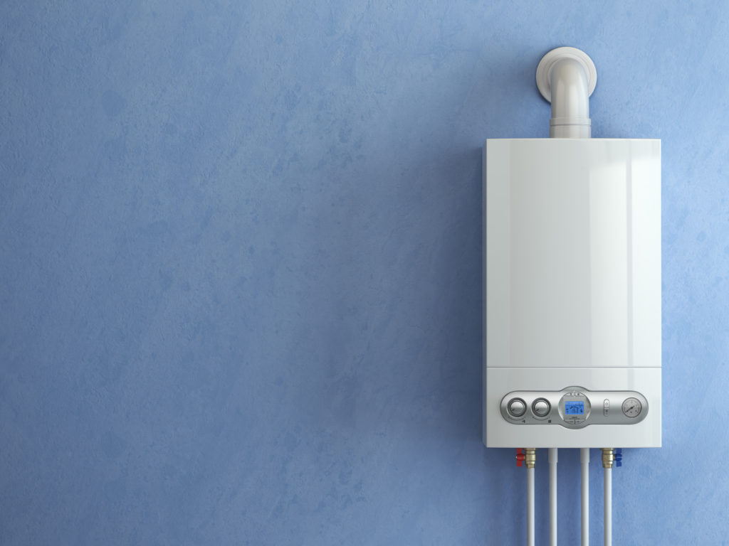 Aquecedor branco instalado em parede azul, com tubulação superior e conexões inferiores aparentes.