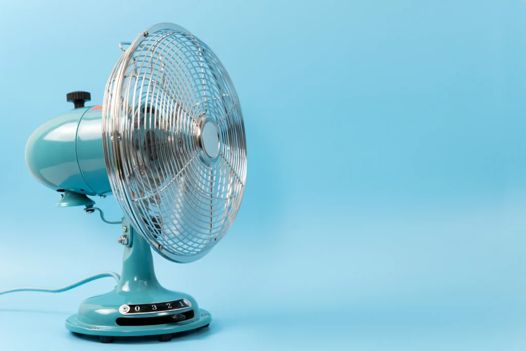 Ventilador de mesa azul com hélices protegidas por grade metálica, ilustrando problemas de ventilador fazendo barulho e possíveis causas do ruído.